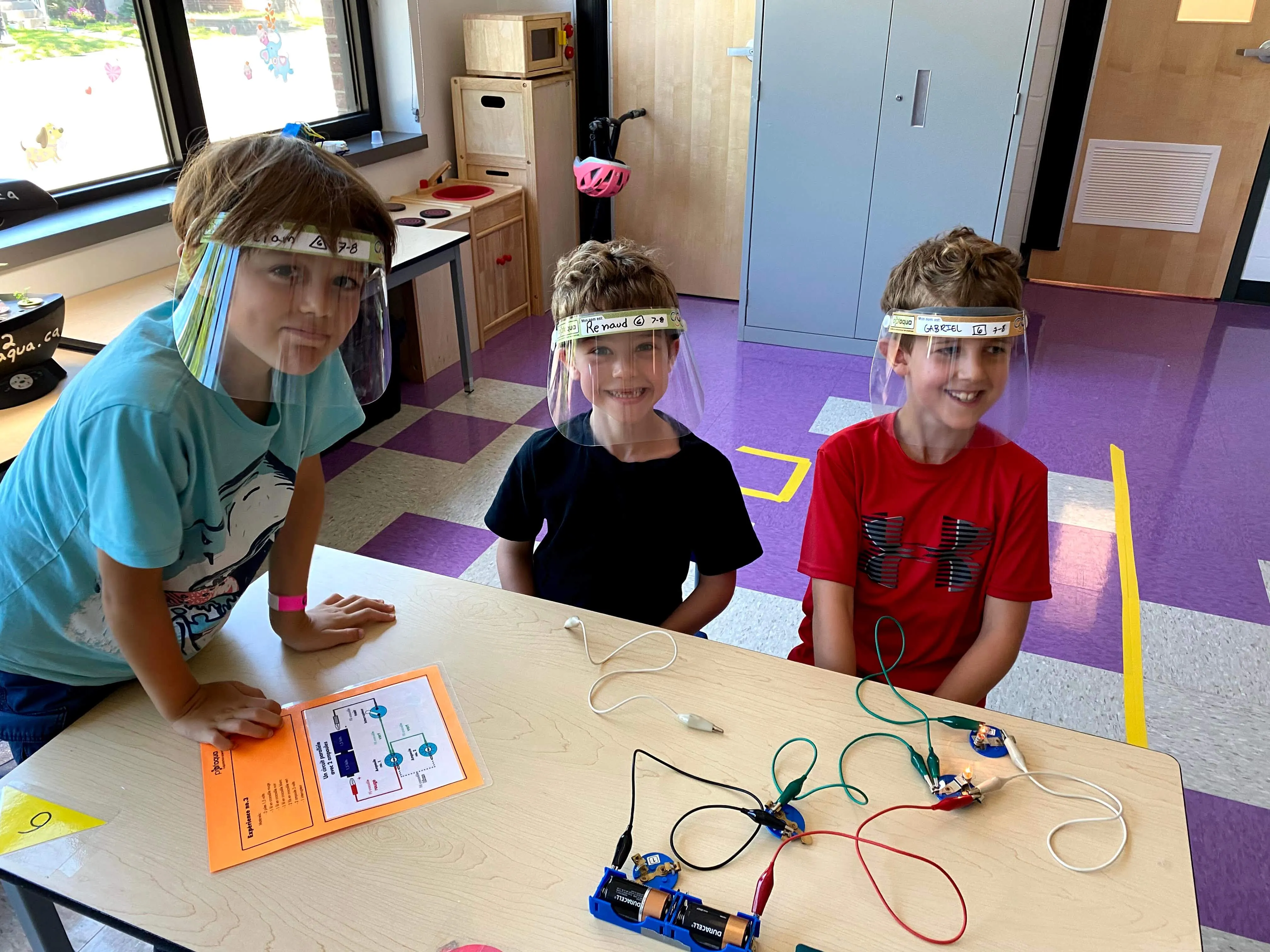 Trois élèves montent ensemble un circuit électrique