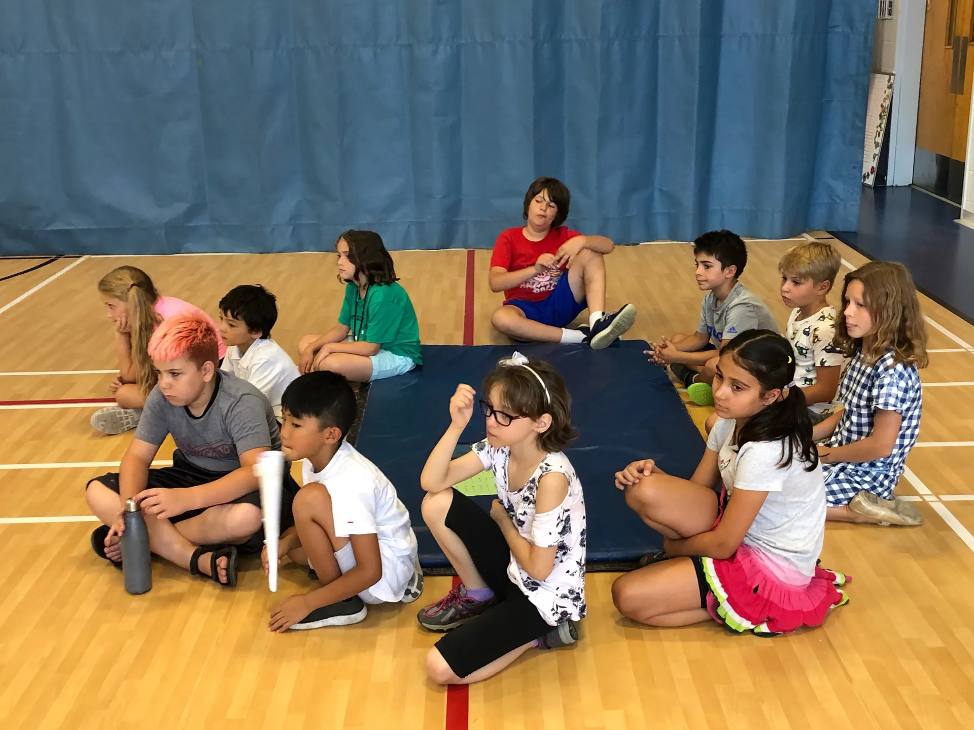 Des élèves assis au gymnase pendant une activité scientifique
